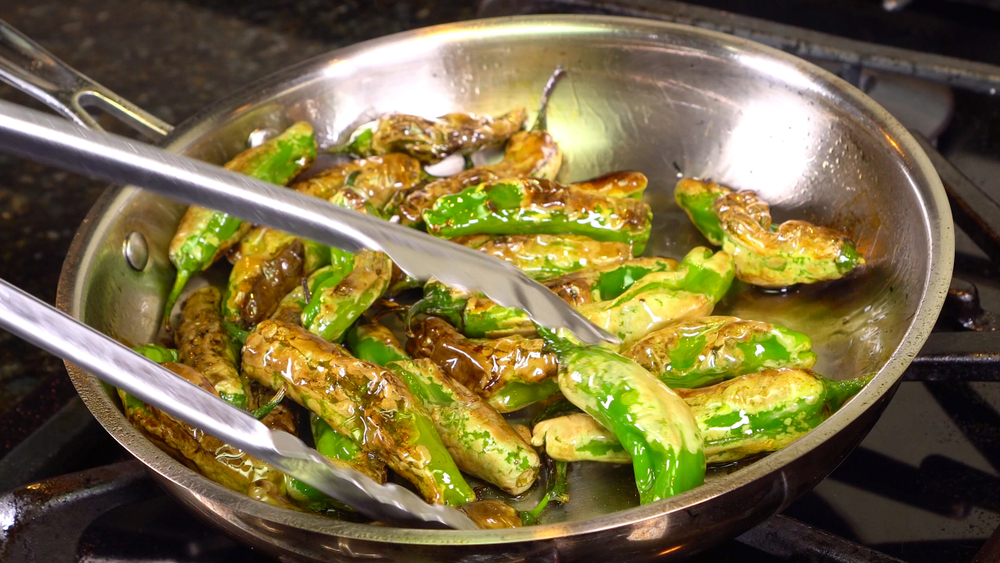 Chiles toreados blistering in a pan.